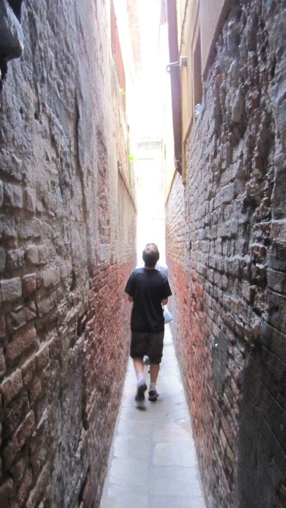 Venice with teens: boy on narrow path. Copyright©2015 reserved to photographer. Contact mapandfamily.com