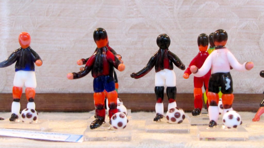Venice with teens: tiny glass footballers in a shop window. Copyright©2015 reserved to photographer. Contact mapandfamily.com