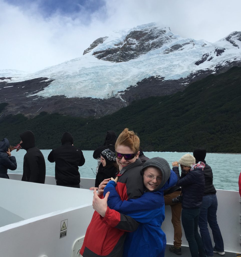 Boys on windswept boat by glacier. Copyright©2015 reserved to photographer. Contact mapandfamily.com