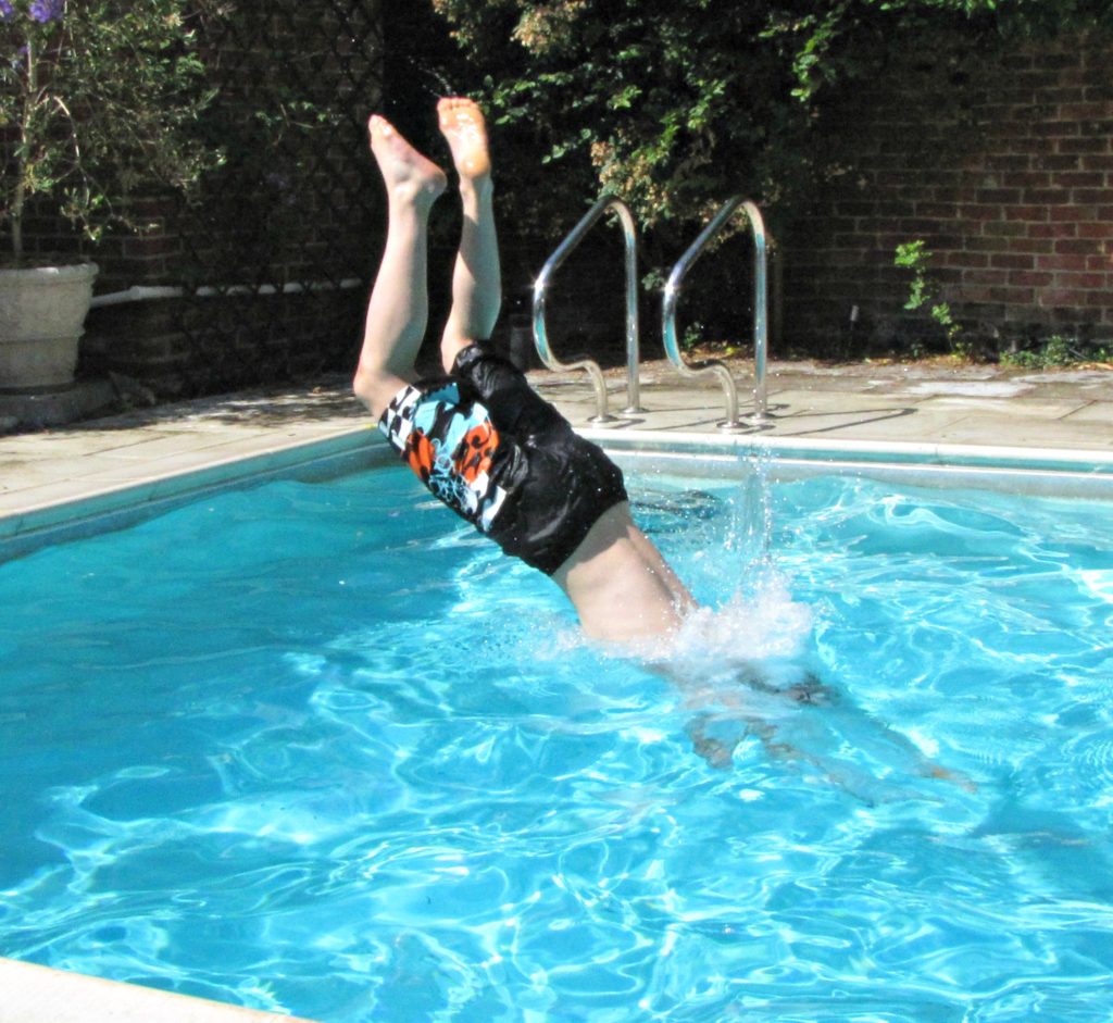 plan a holiday with teenagers: boy diving into pool Copyright©2017 reserved to photographer via mapandfamily.com 