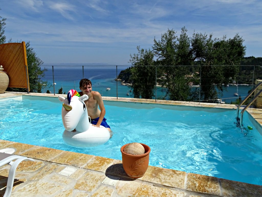 Villa Avra's pool with boy and pool toy and view of Lakka bay. Copyright © 2017 mapandfamily.com 