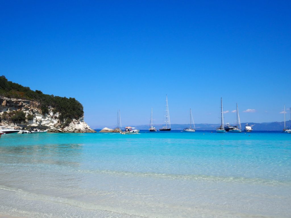 Antipaxos Greece: view of the calm turquoise waters of Voutoumi bay  with yachts moored. Copyright©2018 mapandfamily.com 