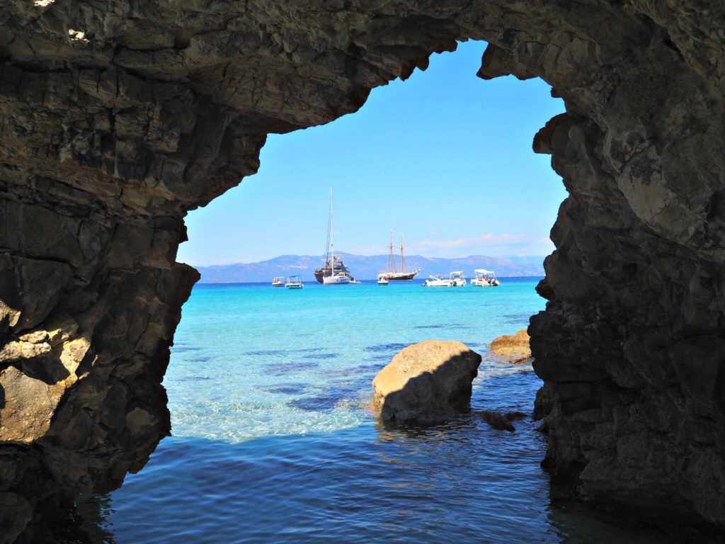 Voutoumi beach Antipaxos: boats seen through arched rocks Copyright©2018 reserved to photographer via mapandfamily.com 
