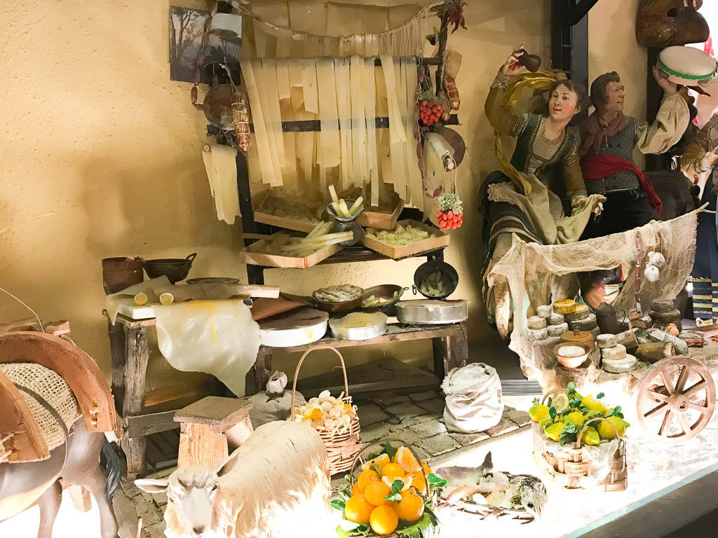 Models depicting traditional pasta making and a cheese cart in Naples nativity scenes