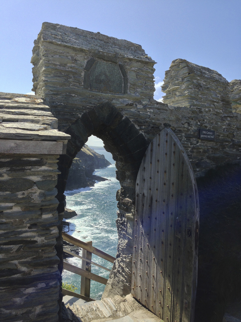 arched doorway in Tintagel castle with view of the sea 