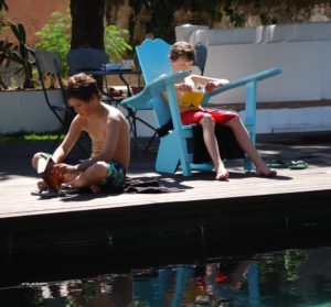Lisbon for kids. Reading by hotel pool, Palacio Belmonte. Copyright©2015 reserved to photographer. Contact mapandfamily.com