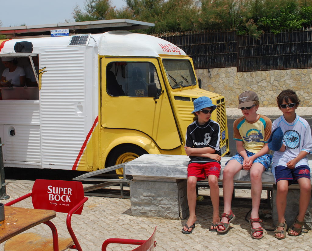 Children sitting beside retro hot dog van, Cascais. Copyright©2015 reserved to photographer. Contact mapandfamily.com