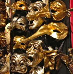 Venice with teens: gold carnival masks on a shop display. Copyright©2015 reserved to photographer. Contact mapandfamily.com