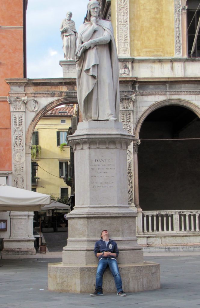Verona with teenagers: boy sitting at base of Dante statue Copyright©2015 mapandfamily.com