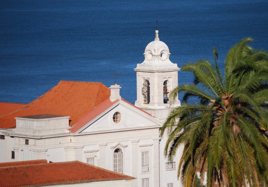 Lisbon family holidays. View of bell tower and terracotta roofs against the blue sea. Copyright©2015 reserved to photographer. mapandfamily.com 