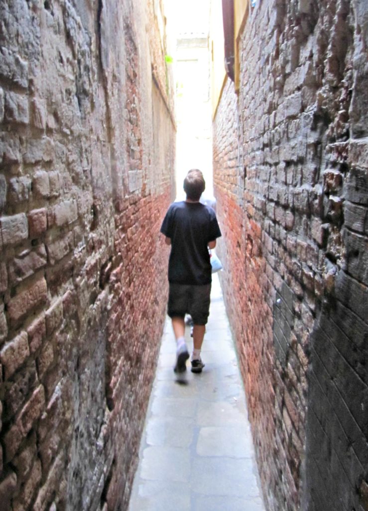 plan a holiday with teenagers: boy in narrow alleyway in Venice Copyright©2017 reserved to photographer via mapandfamily.com 
