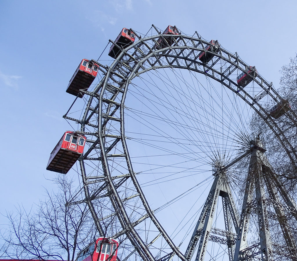 Family trip to Vienna with teens, Vienna ferris wheel with red cabins against blue sky Copyright©2018 reserved to photographer via mapandfamily.com 