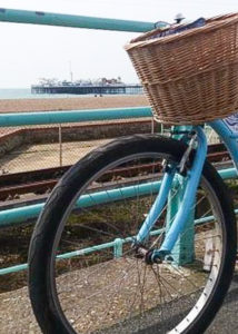 Bike hire Brighton: pale blue beach cruiser bike with basket on the Brighton seafront. copyright @2018 reserved to photographer via mapandfamily.com