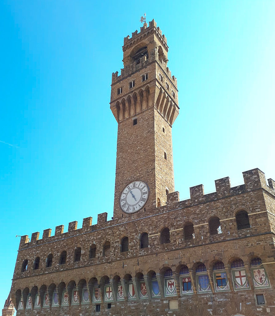 Tower of Palazzo Vecchio against blue sky in Florence. Copyright©2018 mapandfamily.com 