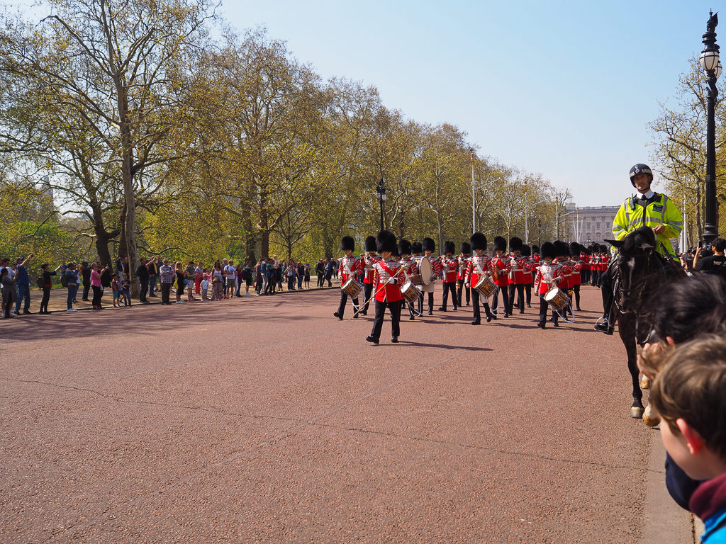 Soldiers in red jackets with bearskin hats, marching down the Mall with a police escort. Copyright ©2019 mapandfamily.com 
