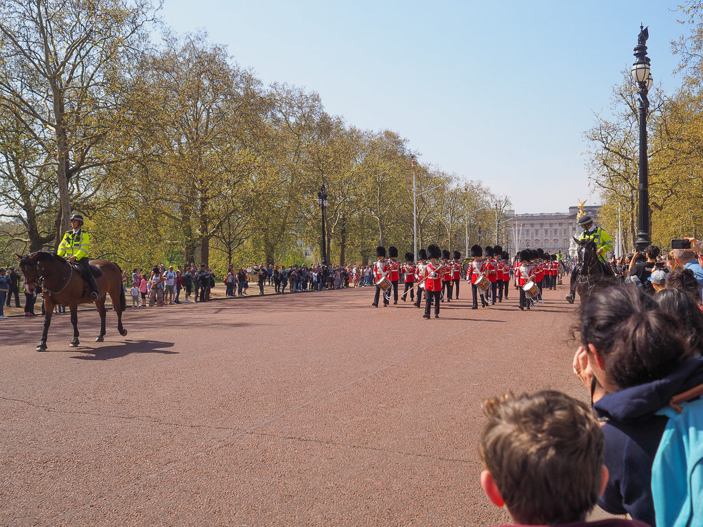 Things to do in London. A band of soldiers in red jackets march down the Mall, flanked by mounted police. Copyright ©2019 mapandfamily.com