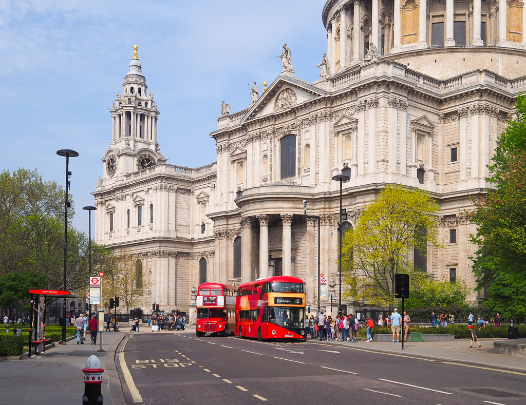 London experiences: a classic red Routemaster bus overtakes a newer model outside St Paul's cathedral. Copyright ©2019 mapandfamily.com