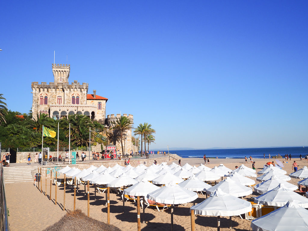The promenade above Tamariz beach in Estoril with beach umbrellas and villa overlooking sea. Copyright ©2019 mapandfamily.com 