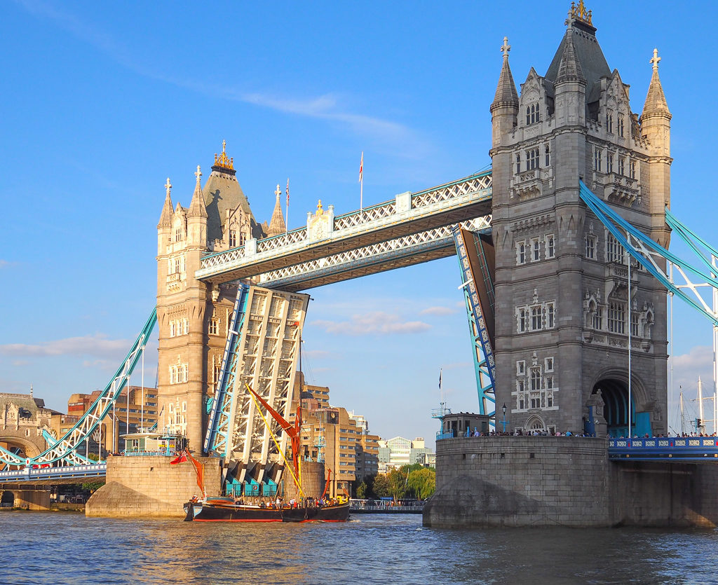 London experiences: the roadway of Tower Bridge splits and lifts to allow a boat to pass along the river Thames. Copyright ©2019 mapandfamily.com