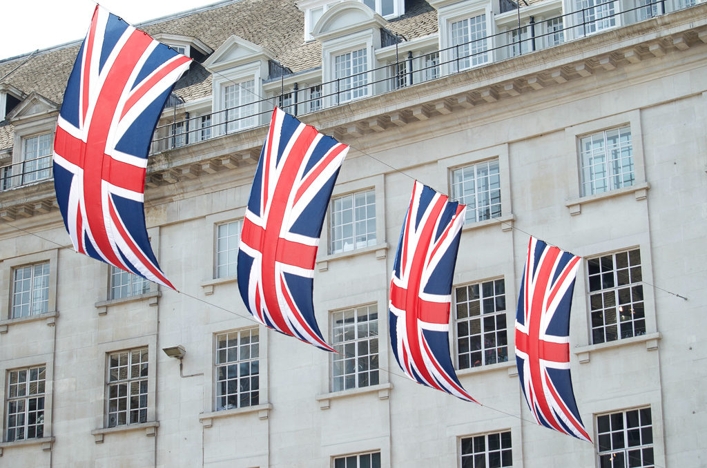 Red, white and blue flags strung across a London street. Photo by A Perry on Unsplash