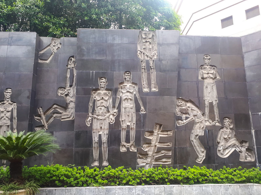 Vietnam itinerary. A wall sculpture at Hoa Lo prison museum, Hanoi. Copyright ©2019 mapandfamily.com