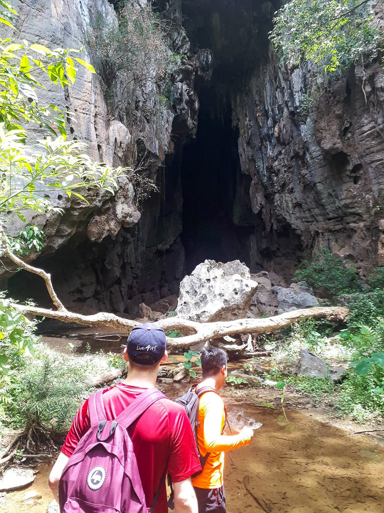 Hanoi to Phong Nha. Two walkers approach the mouth of a large cave. Copyright ©2019 mapandfamily.com
