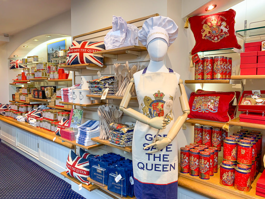 Interior of Buckingham Palace gift shop with model wearing an apron. Copyright ©2019 mapandfamily.com