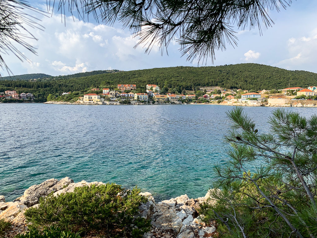 Things to do in Fiscardo. View of bay from wooded walk along peninsula to lighthouses. Copyright ©2020 mapandfamily.com 