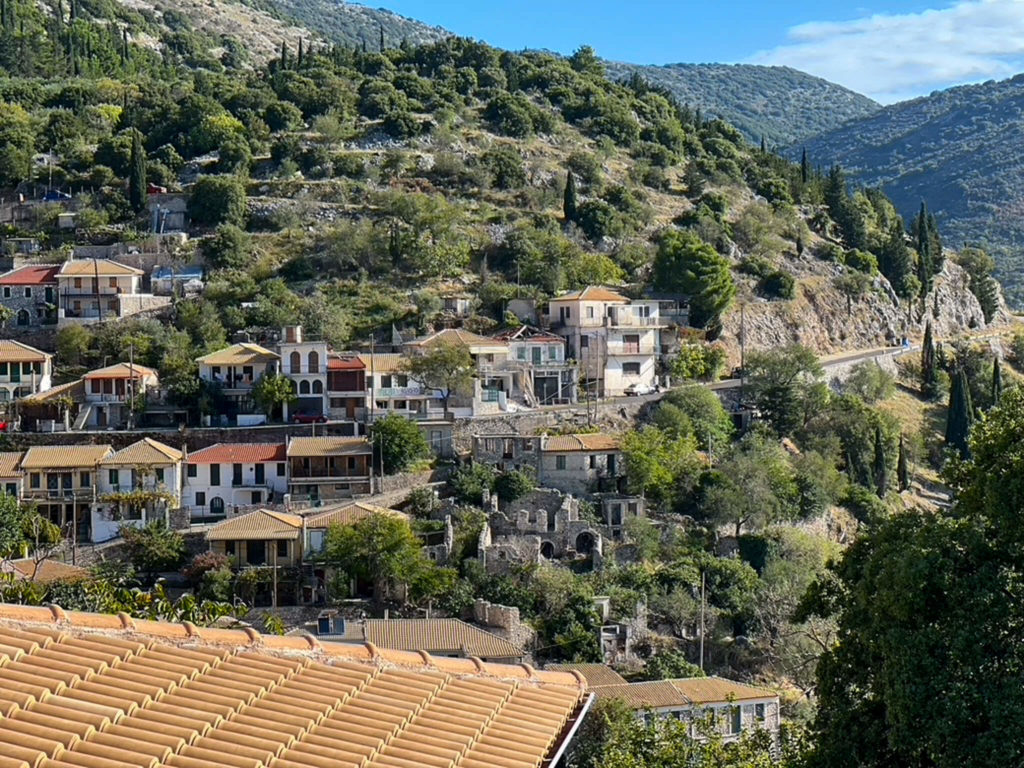 Houses grouped along a road in the mountain village of Exanthia in Lefkada Greece. Copyright@ 2022 mapandfamily.com 