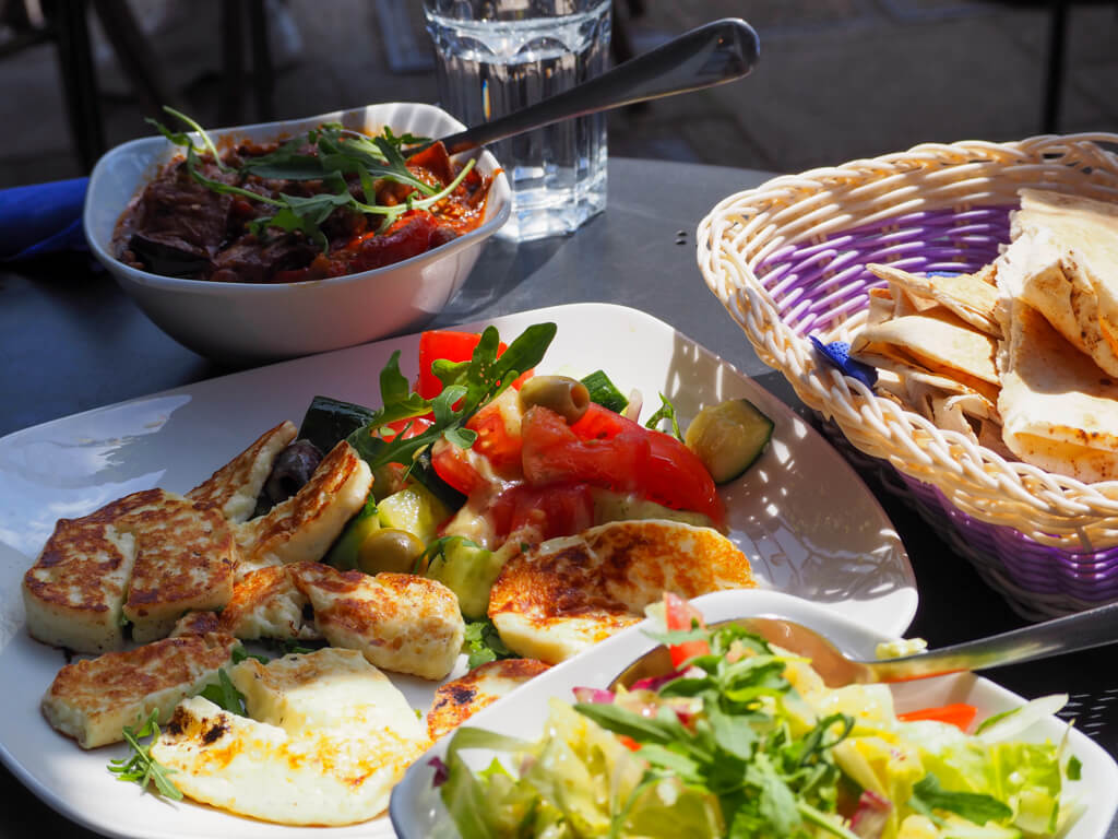 Meze dishes of halloumi and tomatoes, salads and breads. Copyright@2023mapandfamily.com 