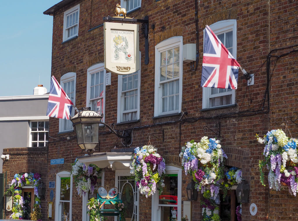 Rose and Crown pub with union flags and hanging baskets of flowers. Copyright@2023mapandfamily.com 