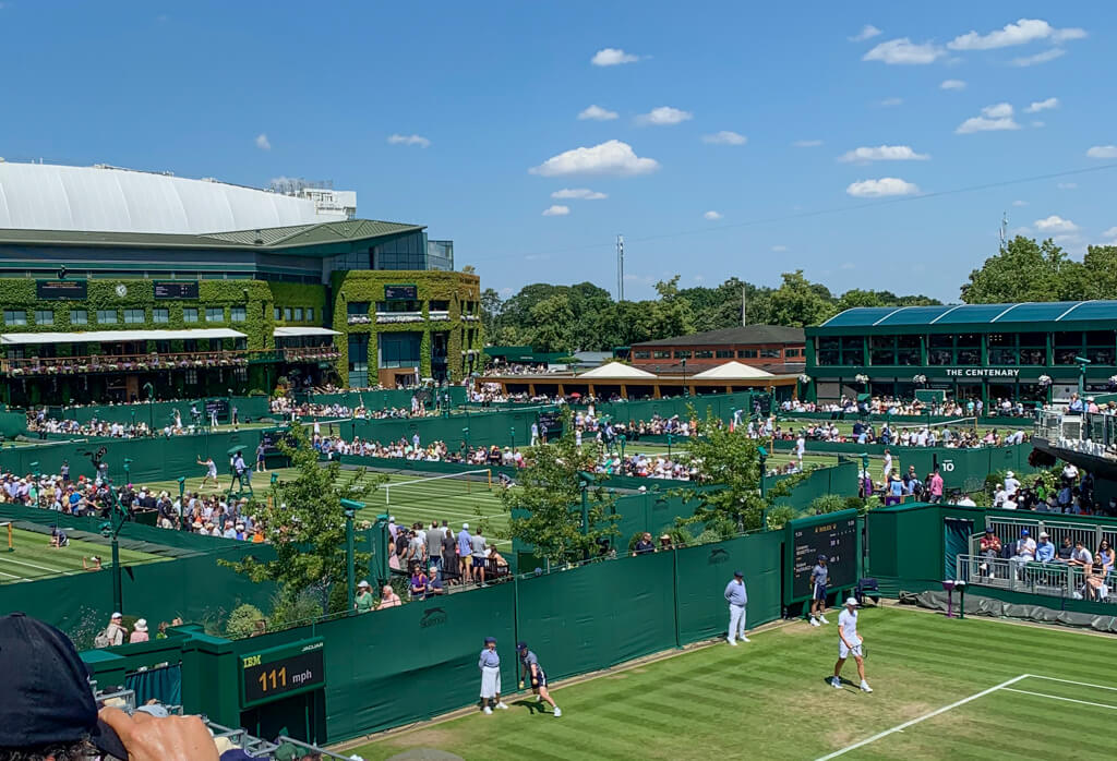 View of Court 12 at Wimbledon from a high tier seat which gives view of other grass courts at the venue. Copyright@2023mapandfamily.com 