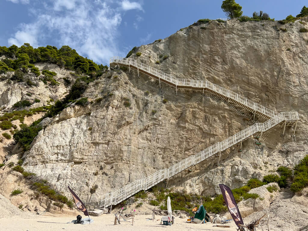White stairway zig zagging down the sheer white cliff at Egremni beach Lefkada. Copyright@2023mapandfamily.com 