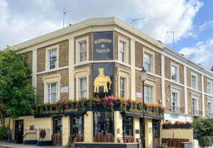 A historic pub called The Elephant and Castle with a golden sign depicting an elephant. Copyright@2023 mapandfamily.com