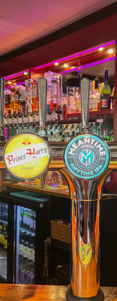 Beer taps at pub bar. One is for Prince Harry lager. Copyright@2023 mapandfamily.com 