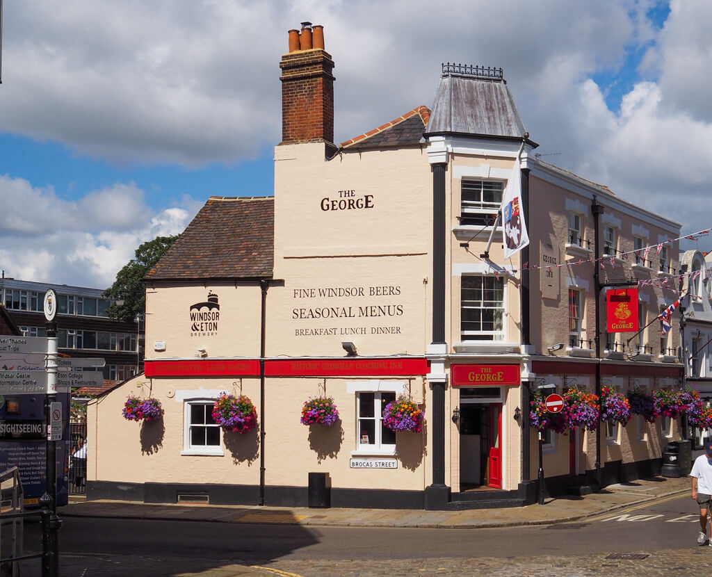 The George pub on a corner site in Eton, painted cream with red trim. Copyright@2023 mapandfamily.com 