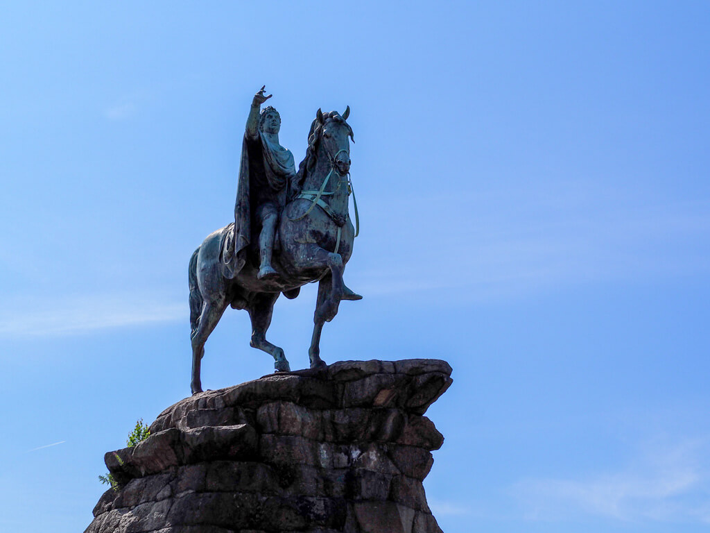 The statue of George III depicted in a heroic pose on horseback. With a blue sky behind. Copyright@2023 mapandfamily.com