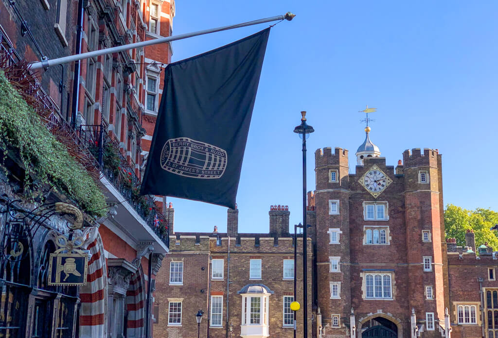 Banner for heritage shop hanging over the street with St James's red brick palace in background. Copyright@2023mapandfamily.com 
