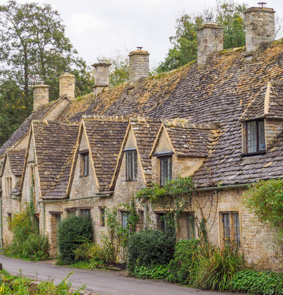 A pretty terraced row of period 
Cotswold cottages in warm sandstone. Copyright @2023 mapandfamily.com 