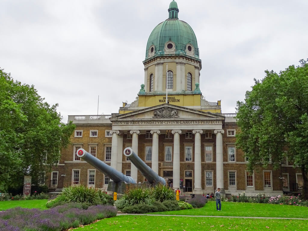 Facade of Imperial War Museum with two cannons pointing outwards from the colonnaded entrance. Copyright @2023 mapandfamily.com 
