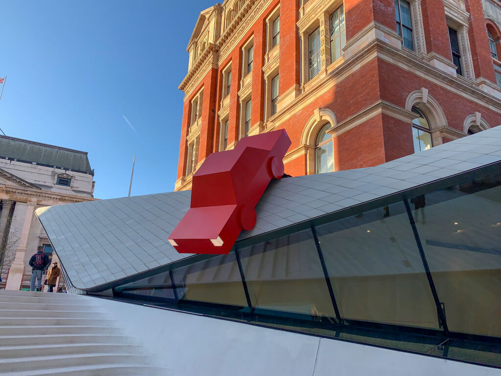 Image of a large stylised car figure on modern sloping roof at V&A museum. Copyright@2023 mapandfamily.com