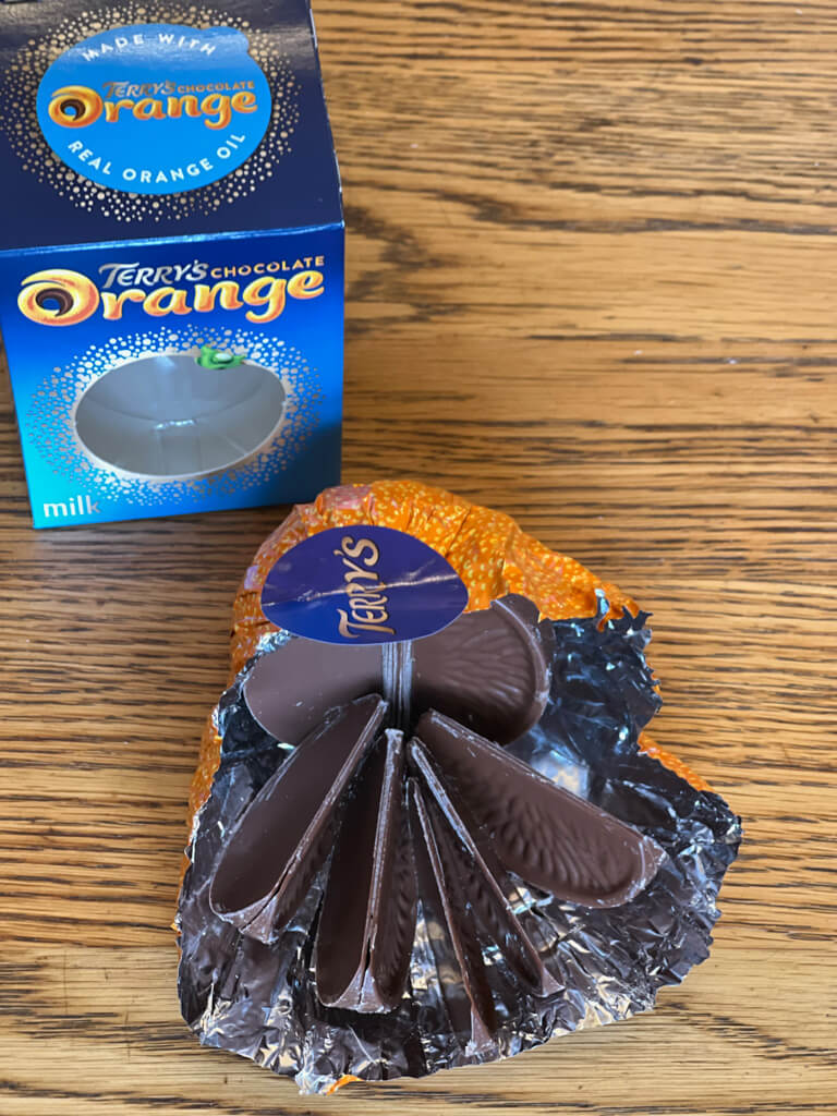 A chocolate orange unwrapped to show the segments of milk chocolate. Copyright 2023@ mapandfamily.com 