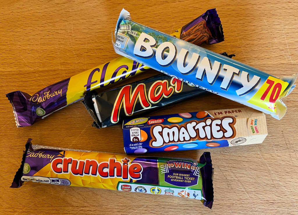 A selection of popular British chocolate bars in colourful wrappers. Copyright@2023 mapandfamily.com 
