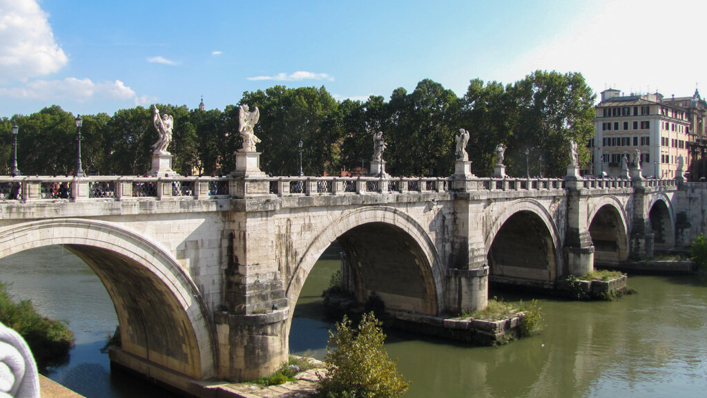 Ponte Sant'Angelo an arched stone bridge with sculptures, in Rome. Copyright@2024 mapandfamily.com 