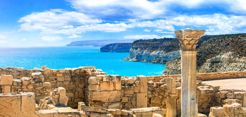 Hottest place in Europe in April: coastline of Cyprus with blue sea and sky and ancient ruins in foreground.