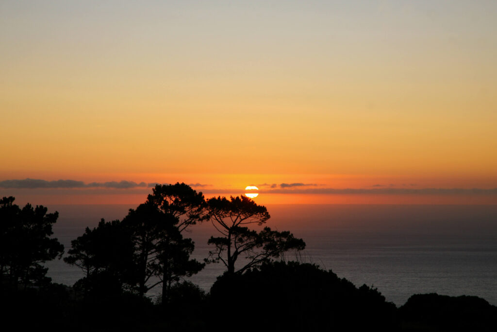 Sunset in Cape Town: Glowing orange sun over ocean in Cape Town. Copyright@2024 Depositphotos