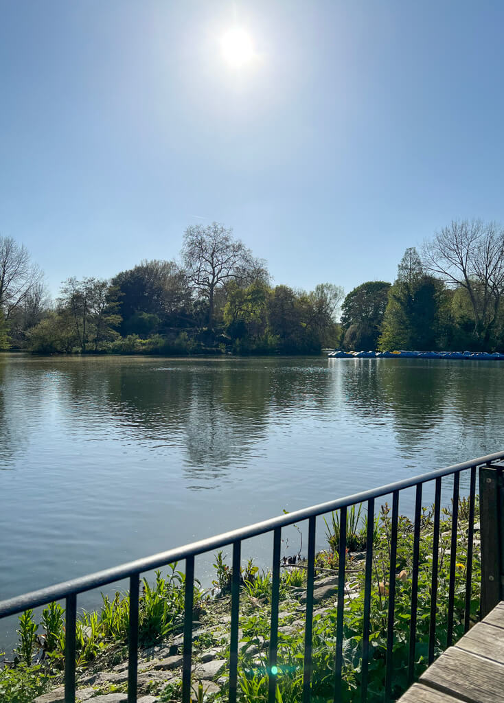 View of Battersea Park boating lake with sunshine on the water. Copyright@2024mapandfamily.com 
