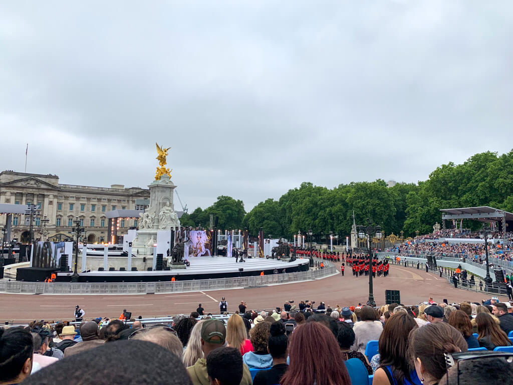 Cloudy skies above Buckinham Palace in June on day of Queen's Platinum Jubilee pageant. Photo taken from spectator stand as guardsmen in red tunics march in. Copyright@2024 Nancy Roberts
