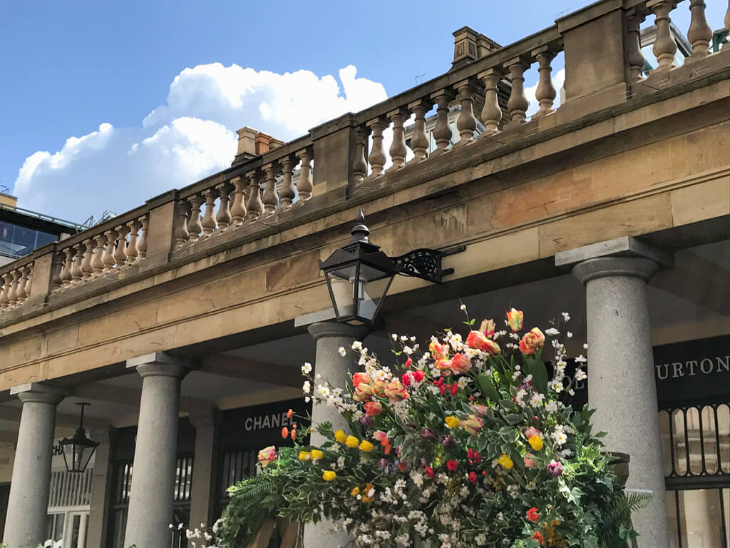 Weather in May in London with blue skies and a display of spring flowers in the collonades at Covent Garden. Copyright@2024NancyRoberts