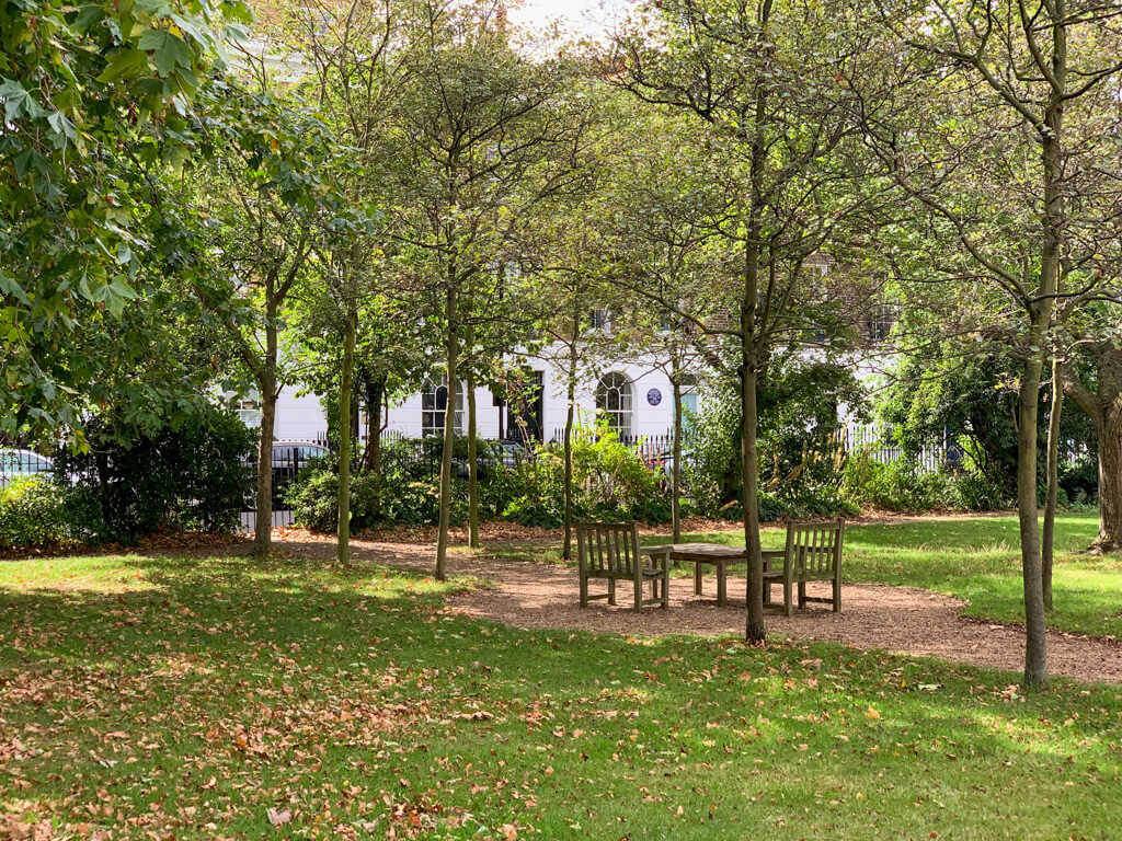 A quiet and leafy garden square with paths and seats in Chelsea London. Copyright 2024@mapandfamily.com 
